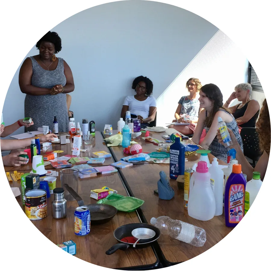 Un atelier de sensibilisation : des participantes autour d'une table couverte de produits du quotidien